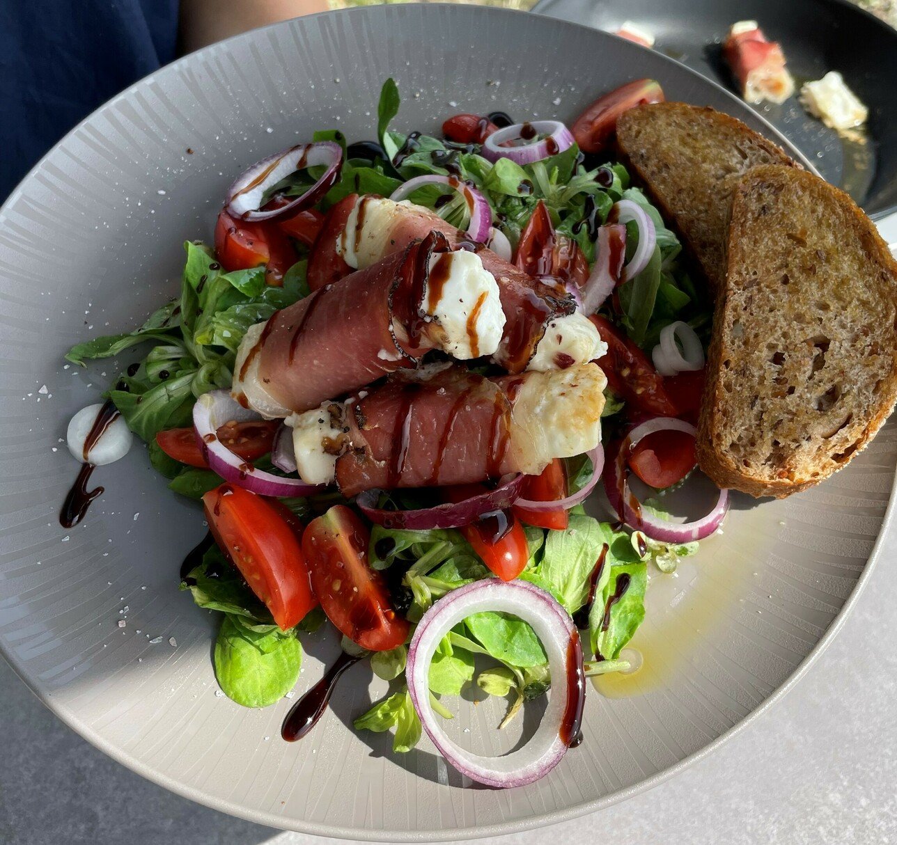 Gebackener Ziegenkäse im Speckmantel auf leichten Salat